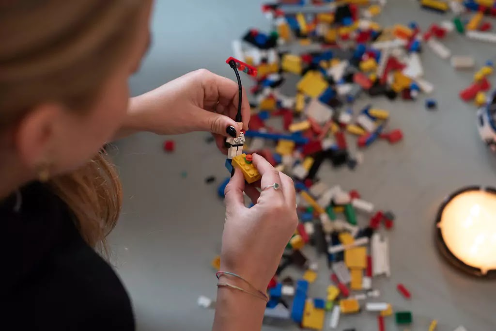 Hands building with bricks during an experience design exercise